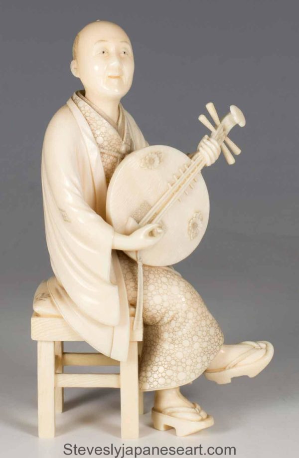 A FINE QUALITY JAPANESE IVORY OKIMONO MUSICIAN