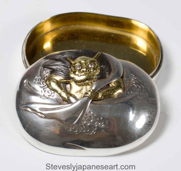 A SOLID SILVER JAPANESE  BOX AND COVER DEPICTING SHOKI